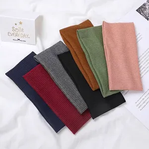 Knitted ribbed elastic headbands shown in seven colors on a white textured fabric background
