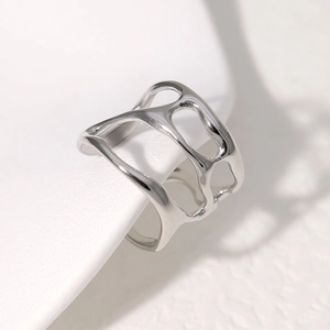 Macro shot of silver irregular hollow wide band ring with polished liquid metal aesthetic