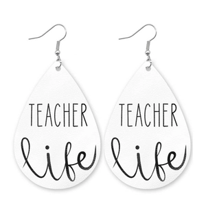Detail view of teardrop faux leather earrings featuring TEACHER life print on white texture