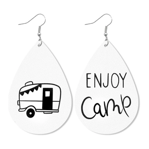 Detail view of leather teardrop earrings featuring a camping van and Enjoy Camp text