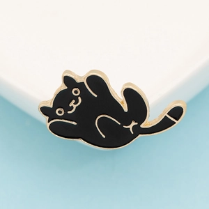 Macro shot of a cute black cat enamel pin featuring gold metal edges and play pose
