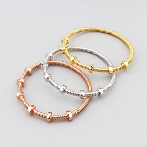Three nut-style screw bangles in gold, silver, and rose gold finish over a white background