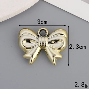Gold bow-shaped charm detail showing dimensions 3cm x 2.3cm and 2.8g weight