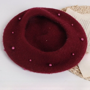 Detail of burgundy wool beret for kids featuring elegant pearl beads for autumn style