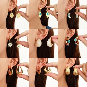 Detail of nine-piece gold earring set with turquoise accents and boho geometric patterns