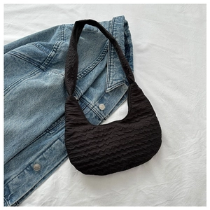 Detail of black pleated crossbody hobo bag with unique puckered texture and soft material