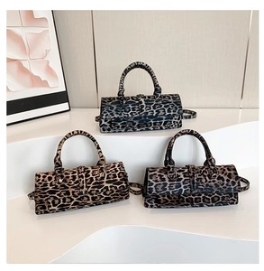Three leopard print PU leather crossbody bags displayed on a minimalist white stand