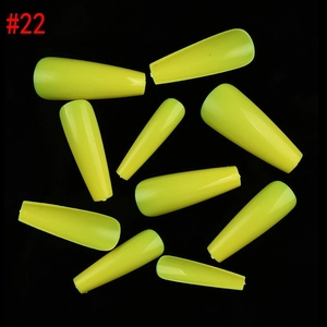 Detailed view of neon yellow coffin press on nails displayed on a black background