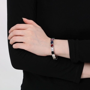 Detailed shot of multi-colored zircon stones set in a polished silver stainless steel bracelet