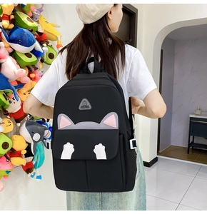 Detail view of the black cat-themed backpack featuring cute 3D ears and white paw prints