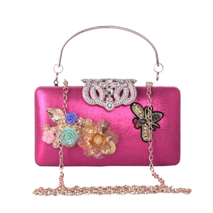Detail of fuchsia evening bag with 3D satin flowers and diamond-encrusted bee clasp