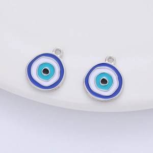 Detailed macro view of two round evil eye charms with blue and white enamel inlay work