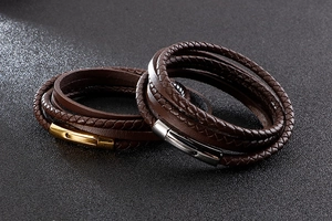Detail of dark brown braided leather bracelets with gold and silver magnetic clasps