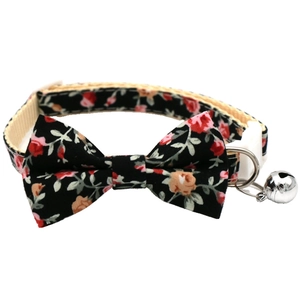 Detail of floral pet collar with white safety buckle, D-ring, and silver bell