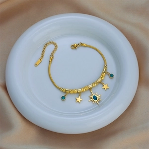 Gold stainless steel snake chain bracelet with celestial turquoise charms on ceramic