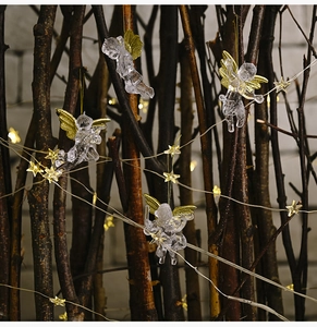 Close-up of clear acrylic Christmas angel ornament with gold wings and LED star lights
