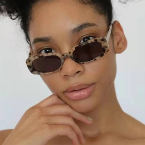 Close-up of stylish rectangular tortoise shell sunglasses on model with dark lenses