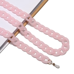 Macro shot of pink matte acrylic eyeglass chain with gold metal rings and silicone loops