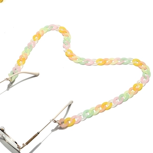 Detail of colorful macaron acrylic eyewear chain links attached to gold frame glasses