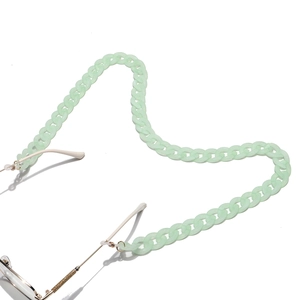 Detail of light green matte acrylic eyewear chain with metal connector on white background