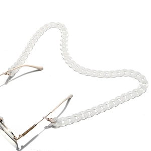 Detail of frosted white acrylic glasses chain with matte texture and gold connectors