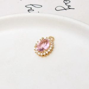 Detail showing an oval pink crystal pendant with sparkling micro-paved cubic zirconia