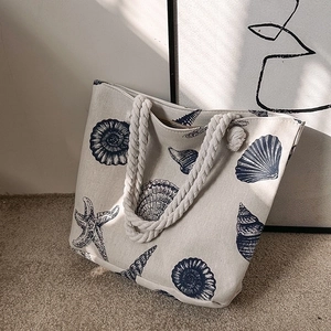 Canvas tote bag with blue ocean prints and thick rope handles for summer beach vacations