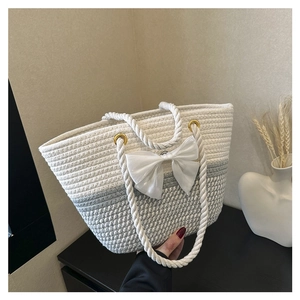 Close-up of woven tote bag with white bow detail and gradient grey cotton rope texture