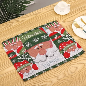 Detail of knitted Christmas placemat featuring Santa Claus and Feliz Navidad text pattern