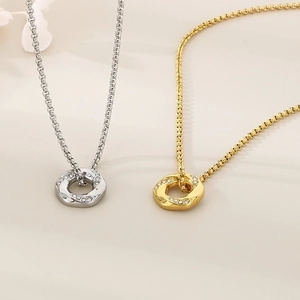 Close-up of gold and silver circle pendants with small diamonds on box chains