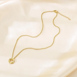 Macro detail of 18K gold plated necklace with hollow hexagon pendant on champagne silk