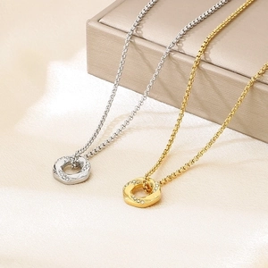 Detail of twisted circle necklaces with micro-inlaid diamonds in gold and silver finishes