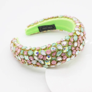 Vue détaillée d'un serre-tête baroque serti de strass multicolores sur tissu vert