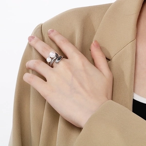 French minimalist irregular silver ring with double pearls worn on finger over suit