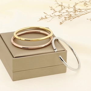 Polished 4mm stainless steel bangles in gold, silver and rose gold on a jewelry box