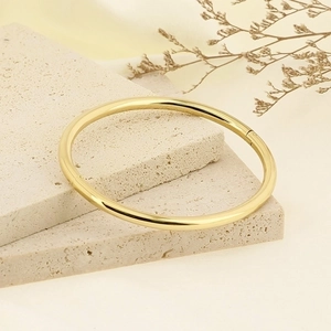 Minimalist 4mm gold polished stainless steel bangle on decorative stone base