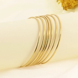 7-piece set of 18K gold plated stackable stainless steel bangles on display stand