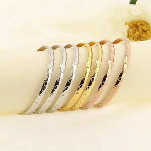 Polished titanium steel bangles in gold, silver, and rose gold with heart pattern