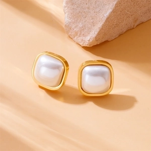 Elegant gold square pearl earrings with vintage geometric minimalist design on stone