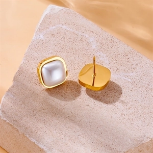 Minimalist square gold stud earrings with white pearl inlay on stone and water ripple background