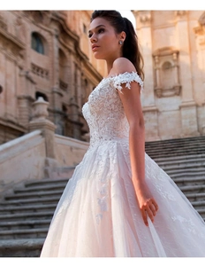 Detailed close-up of off-shoulder neckline with 3D lace embroidery on ivory bridal gown
