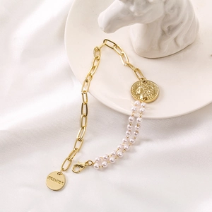 Elegant gold chain bracelet with double row pearls and a queen portrait coin pendant