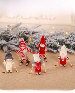Close-up of five knitted wooden ski dolls with colorful hats and skis for Christmas
