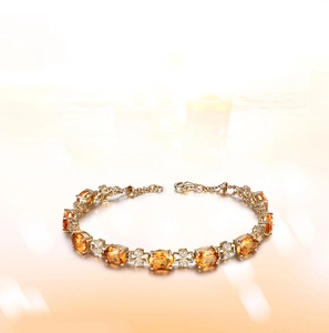 Detail of 18k gold plated bracelet with oval orange gemstones and clover connectors