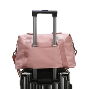 Pink waterproof fitness travel bag with luggage sleeve on black trolley suitcase