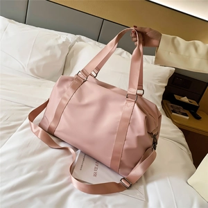 Pink waterproof fitness bag with large capacity and shoulder strap on white bedding