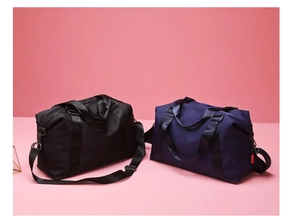 Detail of black and navy large travel bags with dual straps and high-density nylon fabric