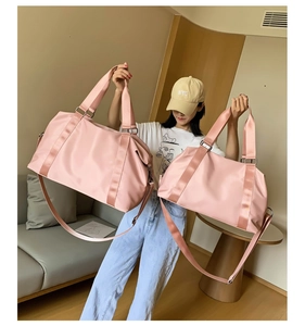 Comparison of large and medium pink waterproof fitness travel bags held by a model