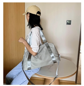 Modern silver gym bag with adjustable shoulder strap shown in lifestyle indoor setting