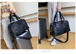 Detail of black waterproof travel bag showing luggage strap and handheld usage mode